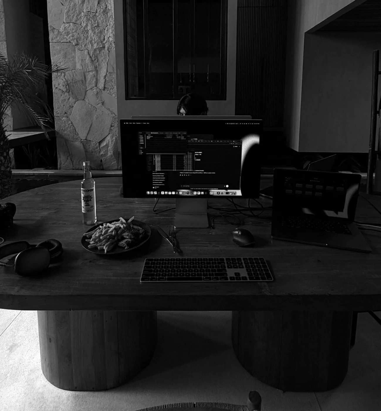 Arbeitsplatz im Halbdunkel, Monitor, Tastatur, Kopfhörer